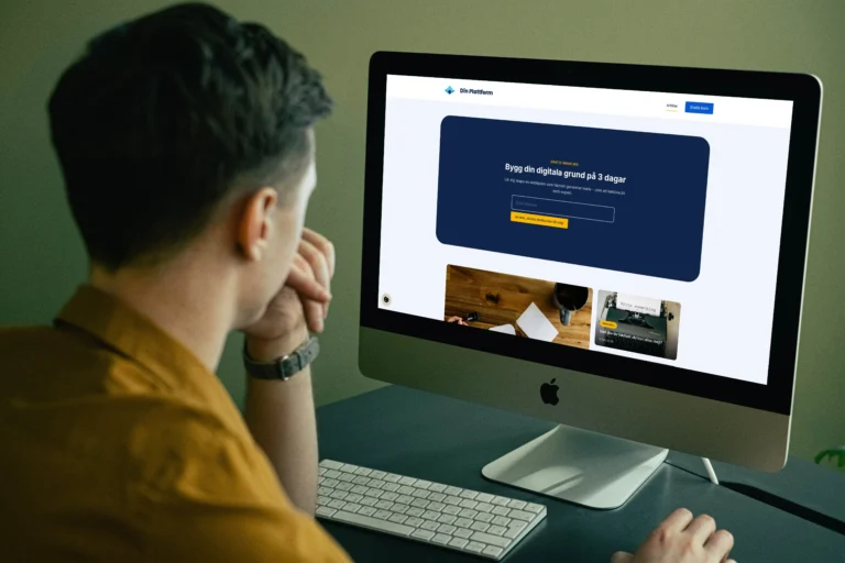 Man som arbetar vid skrivbord och tittar på en iMac med webbplats för digital kurs öppen på skärmen