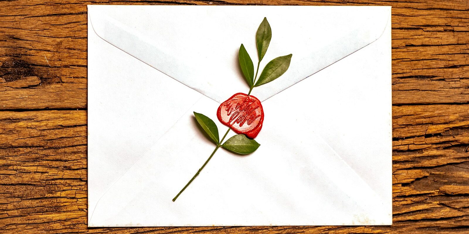 red rose on white envelope